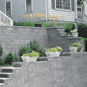 Retaining walls with layered stone design, providing structural support and aesthetic landscaping.